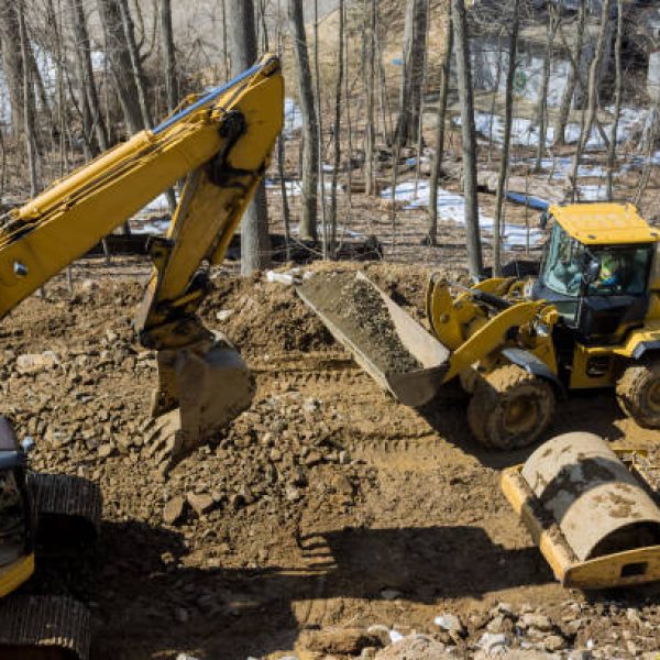 Under construction of a new asphalt road. The excavators, graders and road rollers working on the new road construction site