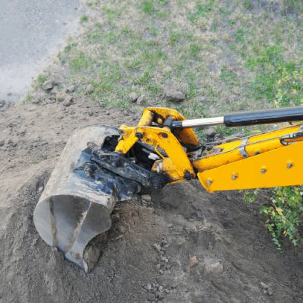 Rusty yellow bulldozer scoop over dirt background